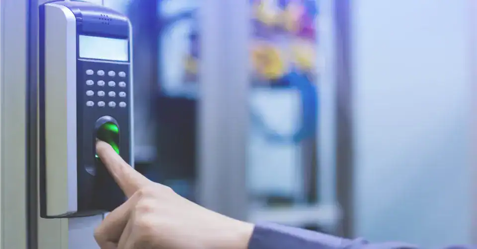 Building for Tomorrow: Trends in Secure Commercial Construction 1 A person uses their finger on a biometric fingerprint scanner with a keypad for access control