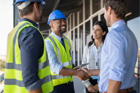 Ensuring Project Success: Proactive Communication in Secure Commercial Construction 1 Two construction workers in safety gear and two business professionals stand outside